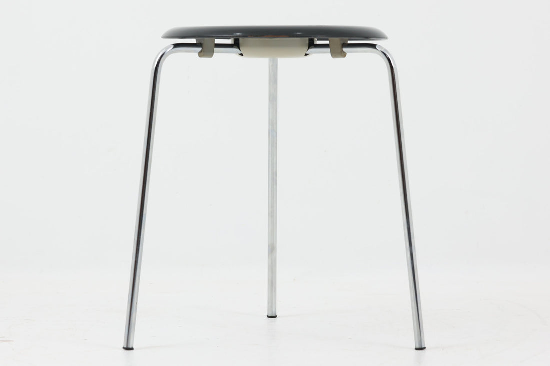 1954年、デンマークのデザイナー、Arne Jacobsen（アルネ・ヤコブセン）によって発表された3本脚のスツール、「DOT（ドット）」。このスツールは、ヤコブセンが手がけた「ルードブレ市庁舎」のロビーで待合席として使用されていました。3本脚のモデルはビンテージ品のみで入手可能です。オフィスや自宅での日常的な使用はもちろん、予備の椅子としても便利なこのスツールは、シンプルなデザインが魅力です。座面の中央がわずかにくぼんでおり、座った際にフィット感を生み出します。シンプルながらもヤコブセンのこだわりが感じられ、また、単なるスツールとしてだけでなく、ソファの横に置いて本や小物を置くサイドテーブルとしても活用できます。